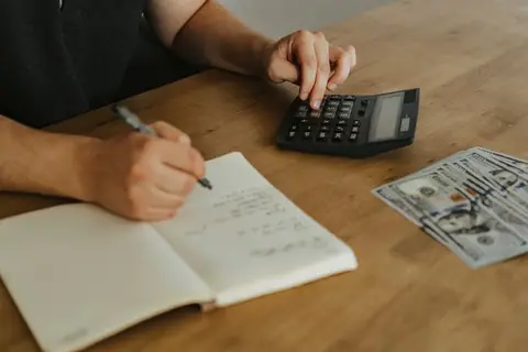 An accountant writing journal entries in a ledger book