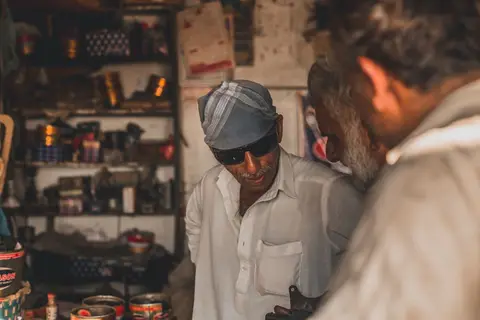 A small business owner sitting across a table from a bank manager, handing over documents.