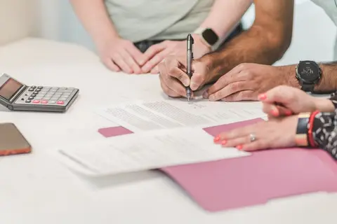 An accountant and a small business owner reviewing documents at a bank.