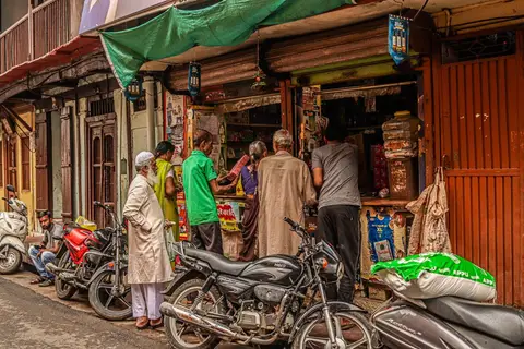 A small business owner in India at a shop counter purchasing equipment or goods