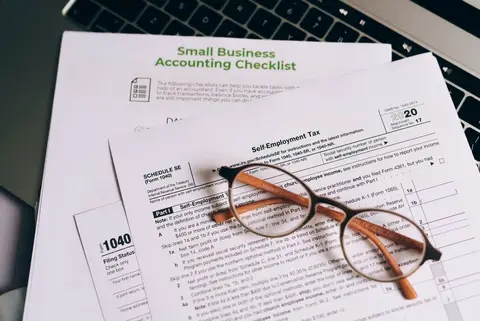 A tax officer reviewing business accounts at a small Indian shop