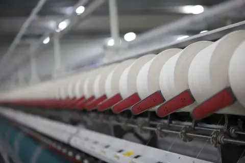A large weaving loom inside an Indian textile factory