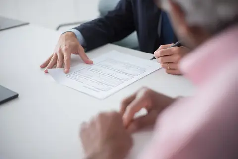 Two people signing a business partnership document