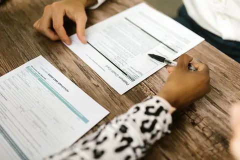 Business people signing documents at a bank meeting in India.
