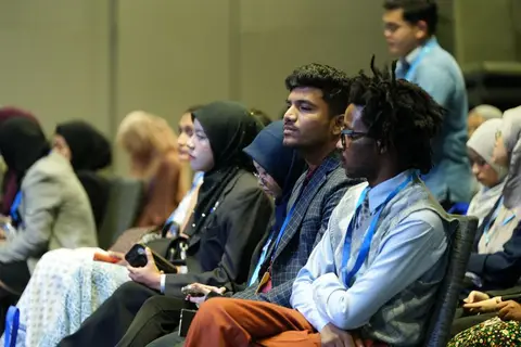 Delegates at an international trade conference representing different countries.