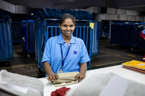 Workers inside a large modern warehouse sorting and packing goods