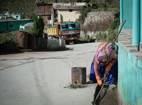 Rural workers, mostly women, doing earthwork on a village road under the MGNREGA scheme.
