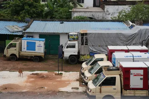 A small business owner in India running a diesel generator during a power cut