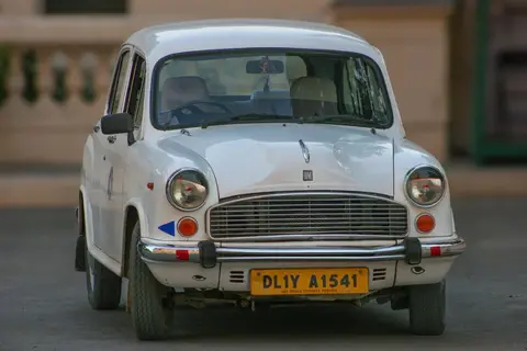 Photo of the classic Ambassador car on an Indian road, representing the limited consumer choices of the License Raj era.