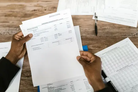 A bank manager reviewing a printed financial statement at a desk, representing how lenders use cash flow data