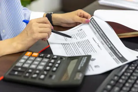 An accountant reviewing a stack of financial documents at a desk, representing the detailed Notes to Accounts