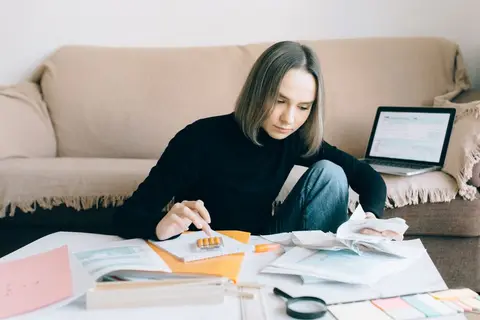 A student carefully reviewing calculations in an accountancy notebook