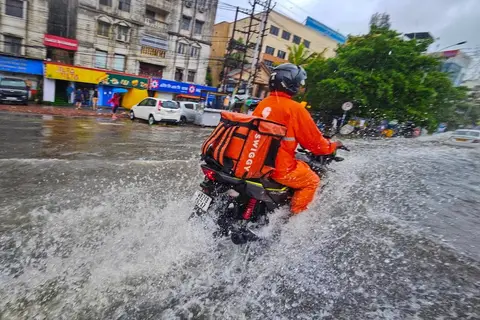 Swiggy food delivery partner on a bike in an Indian city.