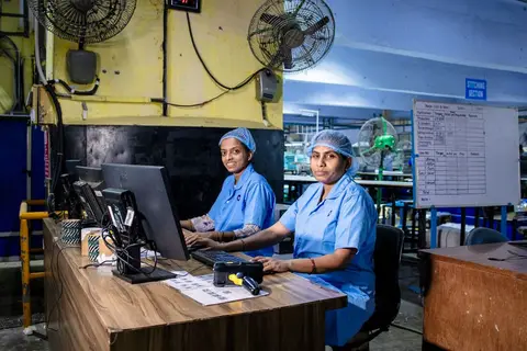 Factory workers on a noisy shop floor trying to communicate with each other