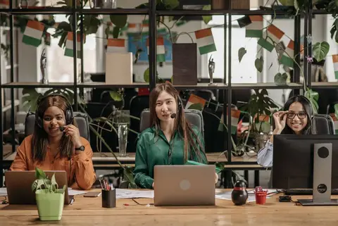 A motivated customer service team working together in a modern Indian office
