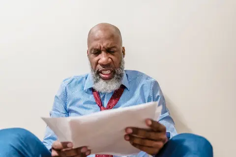 A small business owner in India looking concerned while reviewing financial paperwork