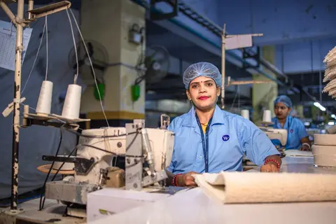 A factory supervisor overseeing workers on the production floor in India