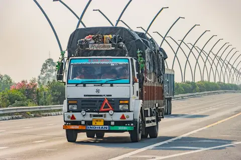 Trucks moving on an Indian expressway, showing the economic benefit of government capital investment in roads.