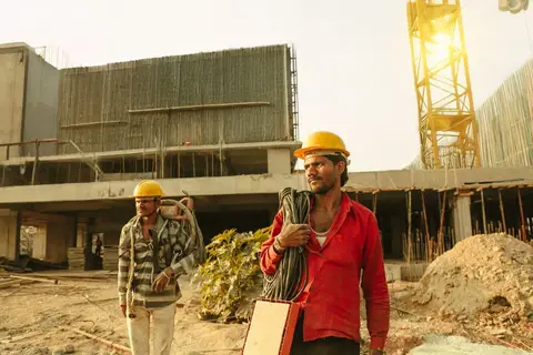 Workers building a highway in India, representing government-led stimulus spending.