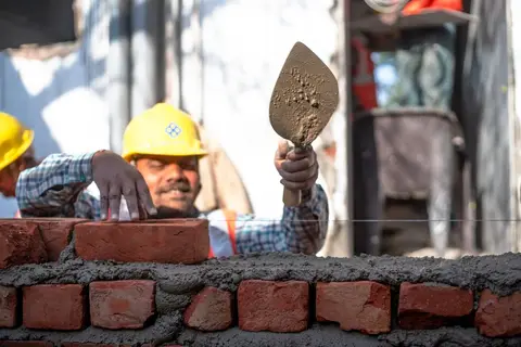 An Indian worker abroad sending money home, representing remittances that go into India's NIFA