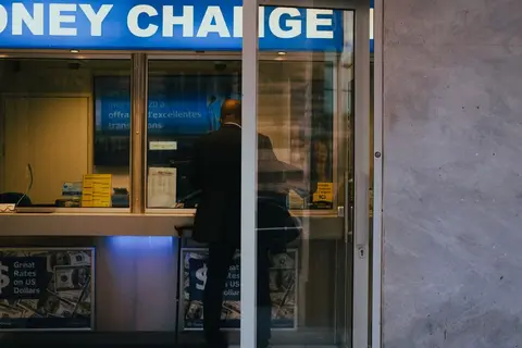 A customer depositing cash at a bank counter in India.