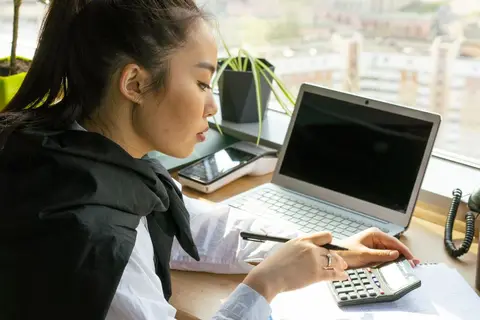 A person at a desk configuring accounting software on a computer before the business starts using it.