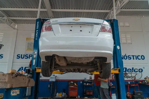 A hydraulic car lift inside an auto-repair garage in India.