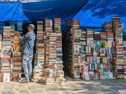 A shop owner in India reviewing account books at the start of a new business year.