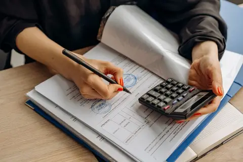 An accountant carefully reviewing a ledger book to find a discrepancy