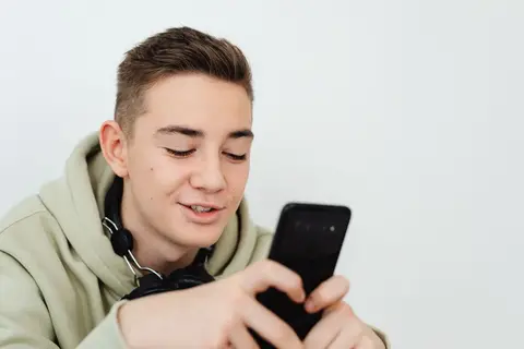A young Indian student browsing a shopping app on a smartphone