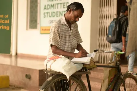 A student buying stationery at a small Indian shop counter