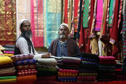 A shopkeeper in India reviewing sales figures at a counter
