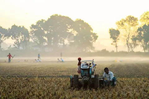 Rural workers digging a pond or canal under an MGNREGA scheme — showing manual wage labour that also builds village infrastructure.