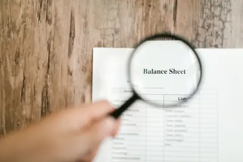 An accountant writing entries in a ledger book.